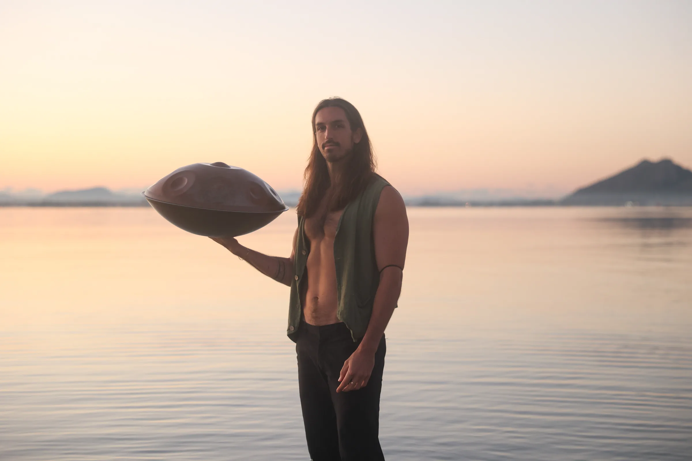 Sandy holding a handpan at sunset